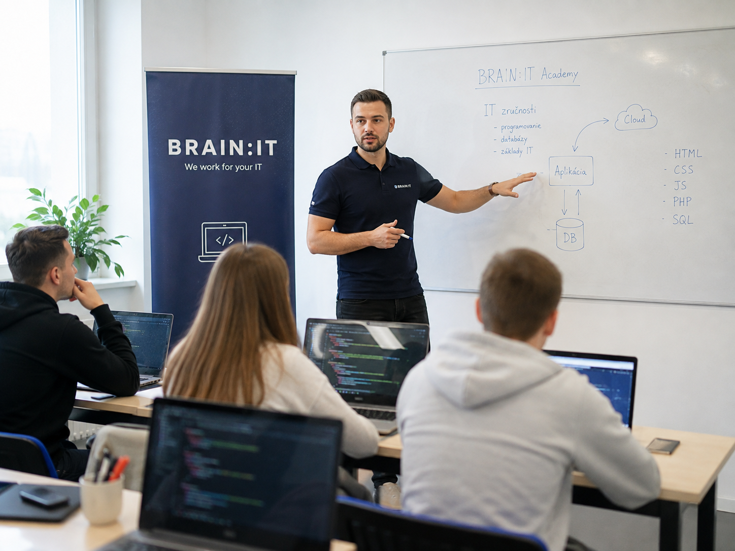 Lektor BRAIN:IT Academy vysvetľuje IT zručnosti pri whiteboarde skupine účastníkov kurzu